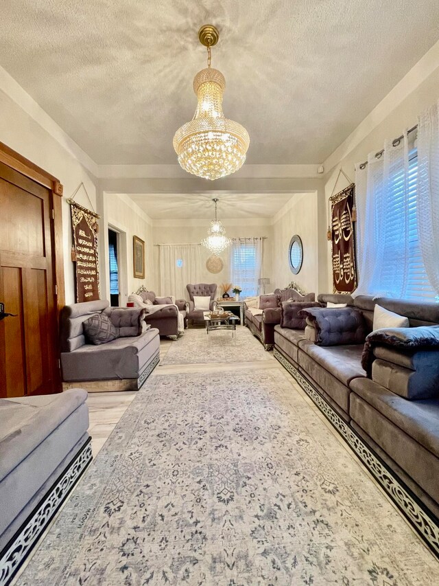 living room with hardwood / wood-style floors, a textured ceiling, an inviting chandelier, and plenty of natural light