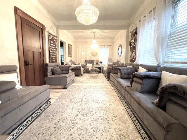 living room with light hardwood / wood-style floors, a notable chandelier, and a wealth of natural light