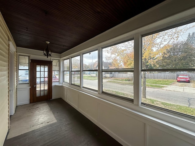 unfurnished sunroom with plenty of natural light and an inviting chandelier