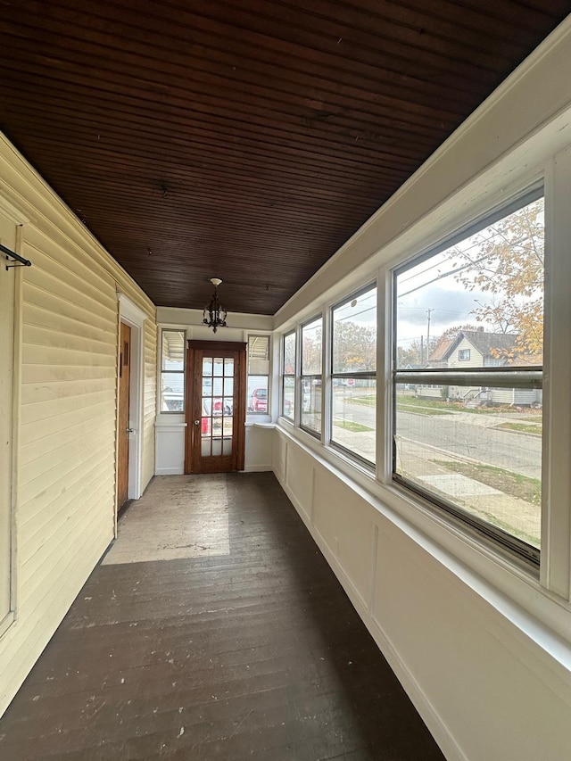 unfurnished sunroom with a chandelier and wood ceiling