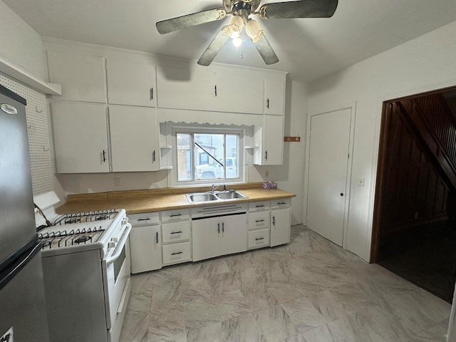 kitchen featuring gas range gas stove, sink, ceiling fan, and white cabinets