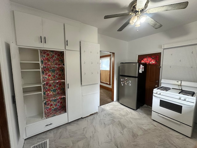 kitchen featuring white cabinetry, white range oven, ceiling fan, and stainless steel refrigerator