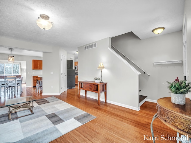 living room with light hardwood / wood-style flooring and a textured ceiling