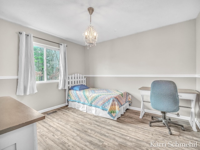 bedroom featuring a chandelier and wood-type flooring