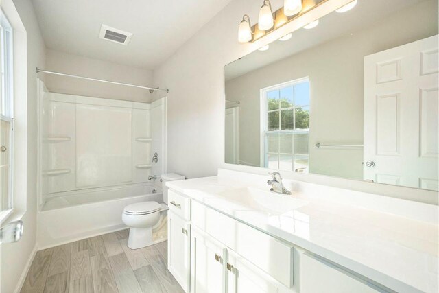 full bathroom featuring vanity, hardwood / wood-style flooring, toilet, and shower / bath combination