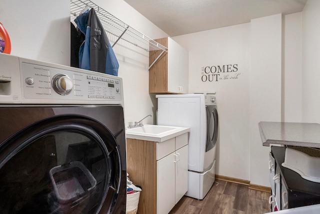 laundry area with sink, dark wood-type flooring, separate washer and dryer, and cabinets