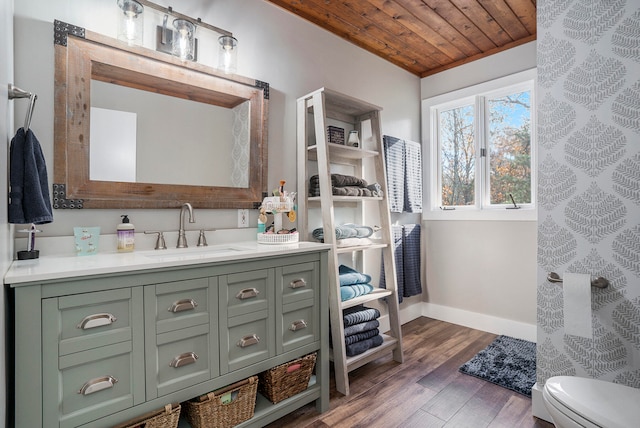 bathroom featuring vanity, hardwood / wood-style floors, toilet, and wooden ceiling