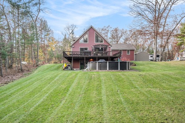 rear view of property featuring a wooden deck and a lawn