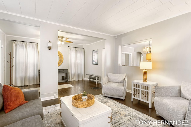 living room featuring ceiling fan with notable chandelier, dark hardwood / wood-style floors, and crown molding