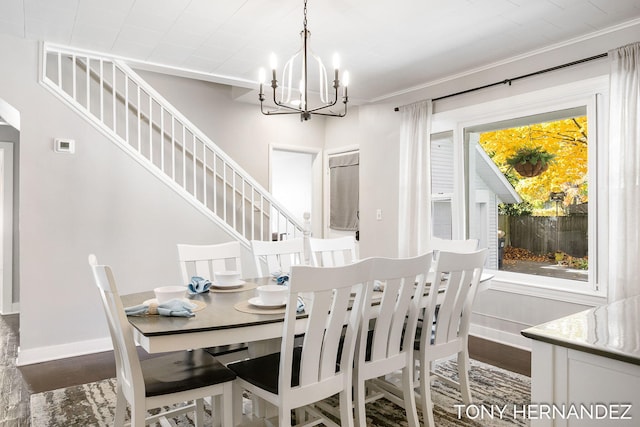 dining space with dark hardwood / wood-style flooring, crown molding, and a notable chandelier