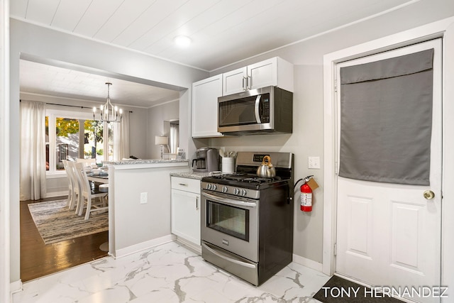 kitchen with white cabinetry, stainless steel appliances, hanging light fixtures, and a chandelier