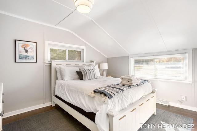 bedroom with dark hardwood / wood-style flooring, lofted ceiling, and multiple windows