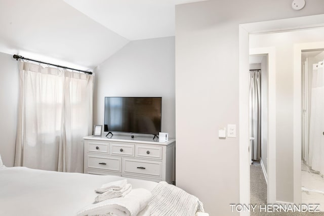 bedroom with lofted ceiling and light carpet