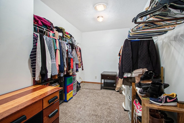 walk in closet featuring light carpet