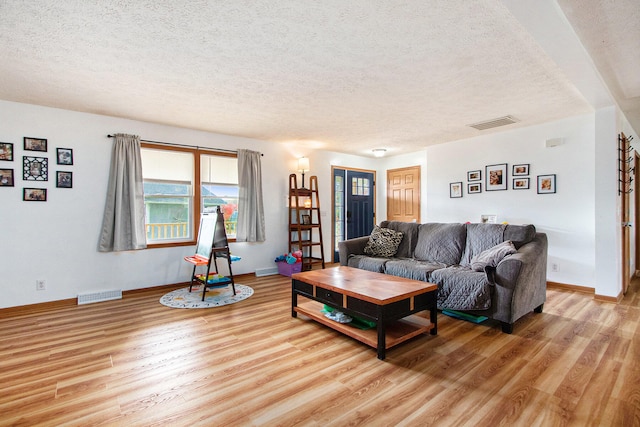 living room featuring light hardwood / wood-style flooring and a textured ceiling