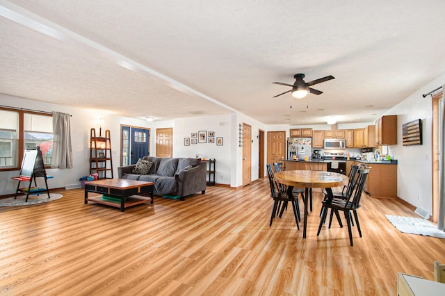 dining space featuring ceiling fan, a textured ceiling, and light hardwood / wood-style flooring