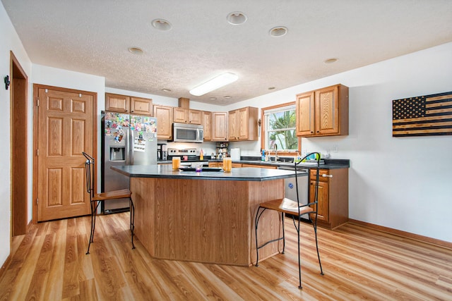 kitchen featuring light hardwood / wood-style floors, appliances with stainless steel finishes, and a center island