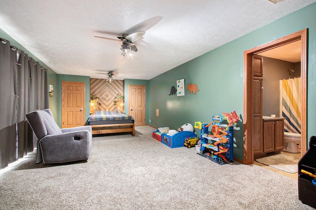 carpeted bedroom with ensuite bath, a textured ceiling, and ceiling fan