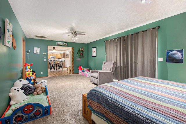 bedroom featuring a textured ceiling, carpet, and ceiling fan