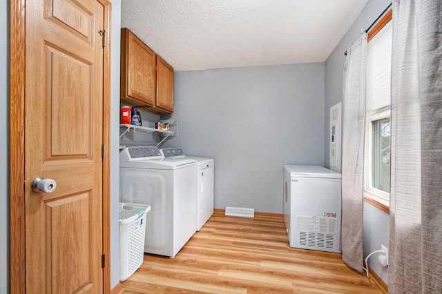 washroom with light hardwood / wood-style floors, cabinets, plenty of natural light, and independent washer and dryer