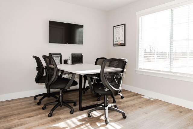 home office with light hardwood / wood-style flooring and plenty of natural light