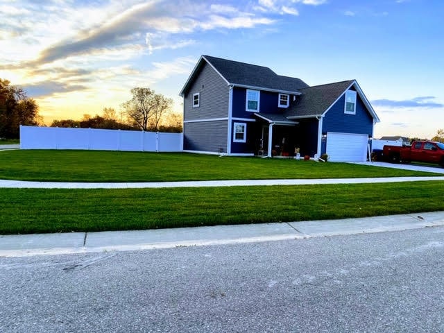 view of front of home with a garage and a yard