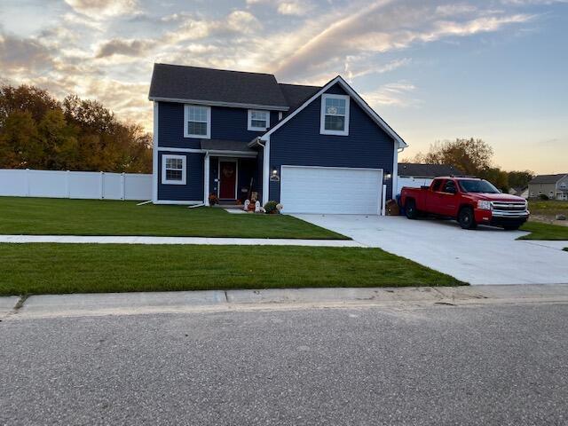 view of front of property with a yard and a garage