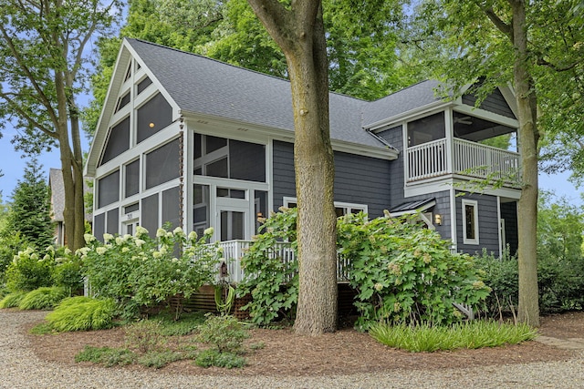 view of side of property with a sunroom and a balcony