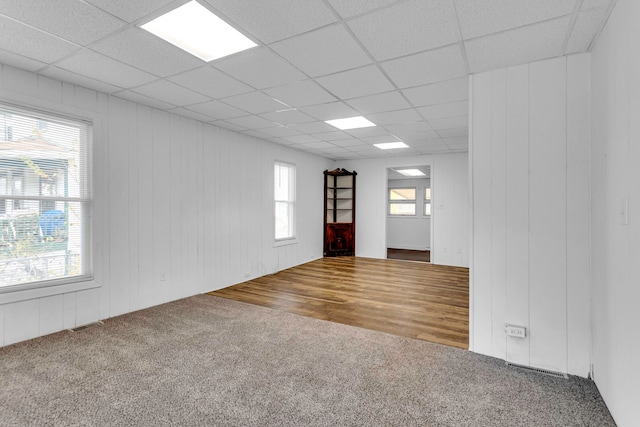 spare room with a paneled ceiling and wood-type flooring