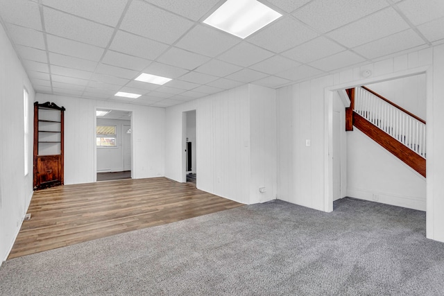 spare room with a paneled ceiling and dark hardwood / wood-style flooring