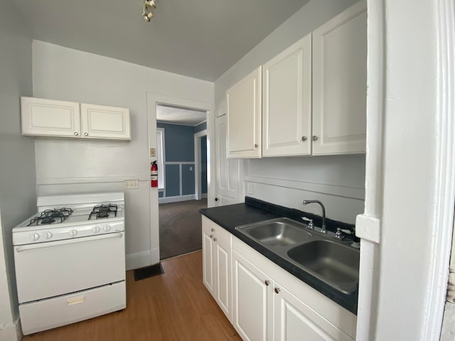 kitchen with white cabinetry, gas range gas stove, sink, and dark hardwood / wood-style flooring