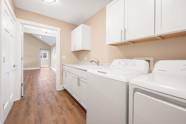 laundry area with cabinets, hardwood / wood-style floors, separate washer and dryer, and sink