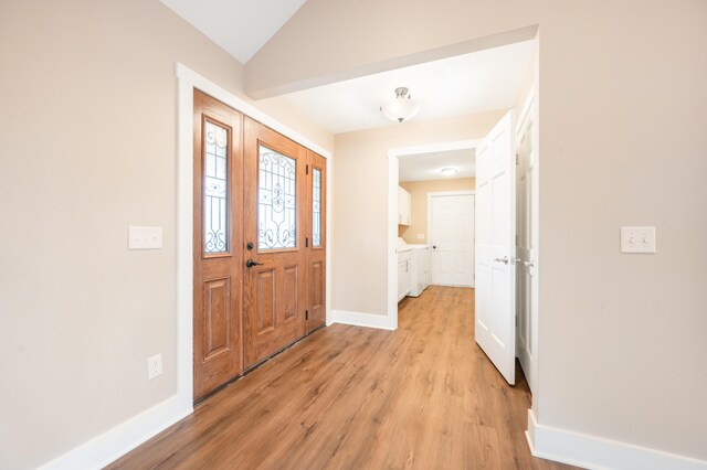 foyer with light hardwood / wood-style flooring and lofted ceiling