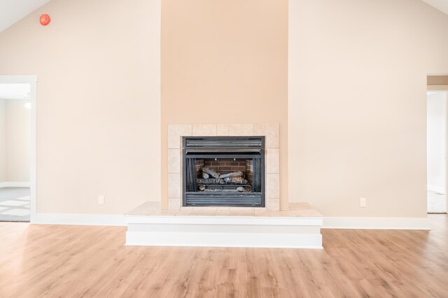 details with hardwood / wood-style floors and a tiled fireplace