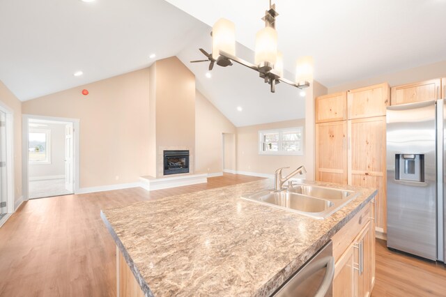 kitchen featuring stainless steel appliances, light wood-type flooring, light brown cabinets, sink, and a kitchen island with sink