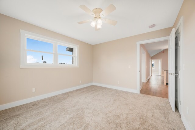 carpeted spare room with ceiling fan