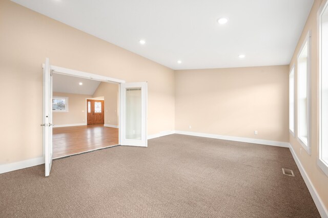 carpeted spare room with lofted ceiling