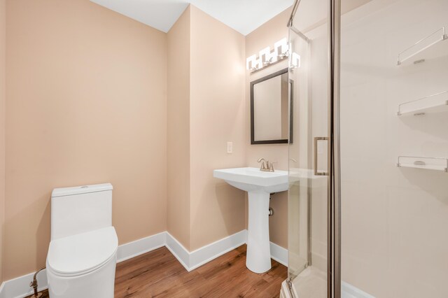 bathroom featuring walk in shower, hardwood / wood-style floors, and toilet