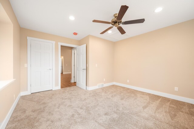 unfurnished bedroom featuring light carpet and ceiling fan