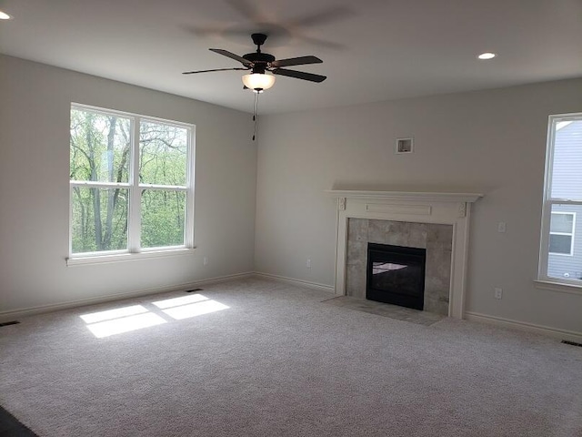 unfurnished living room featuring ceiling fan, light carpet, and a fireplace