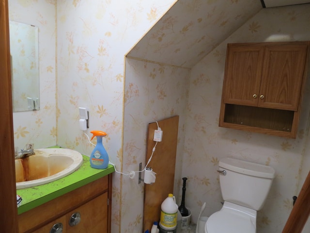 bathroom with vanity, toilet, and vaulted ceiling