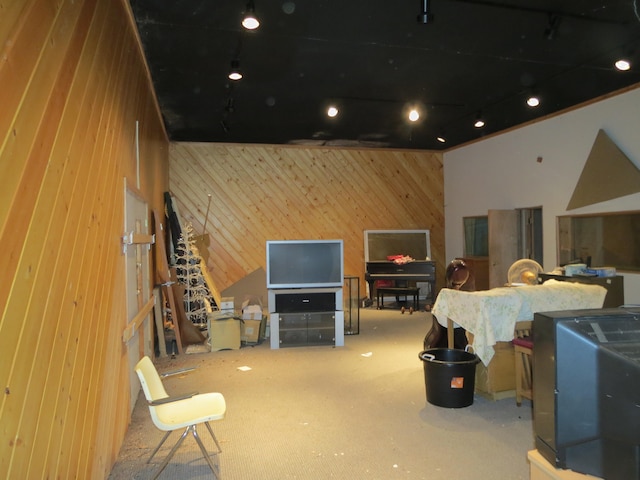 interior space with a towering ceiling, wood walls, and carpet flooring