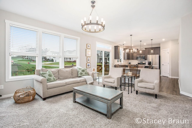 living room featuring hardwood / wood-style floors, a wealth of natural light, and an inviting chandelier