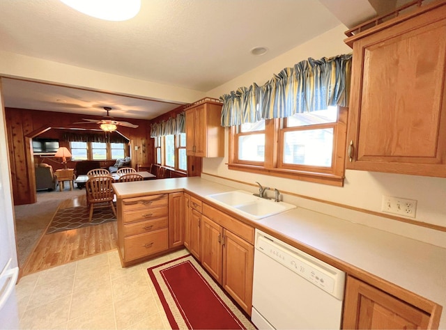 kitchen with dishwasher, kitchen peninsula, sink, light tile patterned floors, and ceiling fan