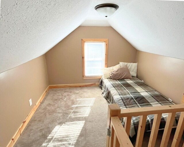 unfurnished bedroom featuring a textured ceiling, carpet flooring, and vaulted ceiling