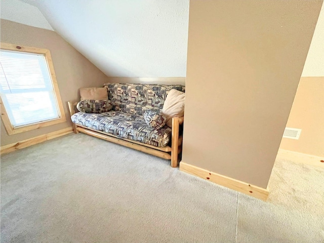 living area featuring vaulted ceiling and carpet flooring