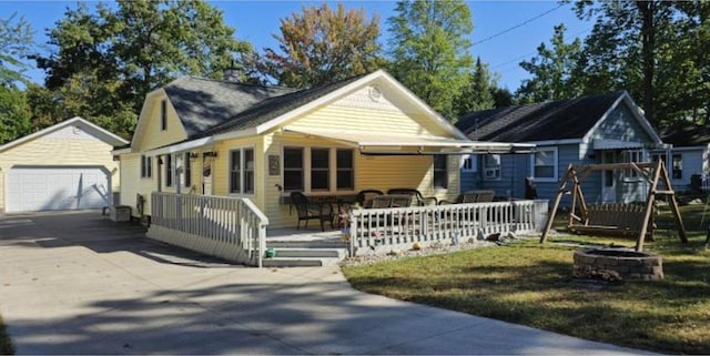 bungalow-style home with a front yard, an outbuilding, and a garage