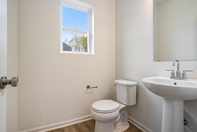 bathroom with toilet, hardwood / wood-style flooring, and sink