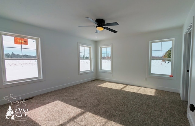 spare room featuring ceiling fan and dark colored carpet