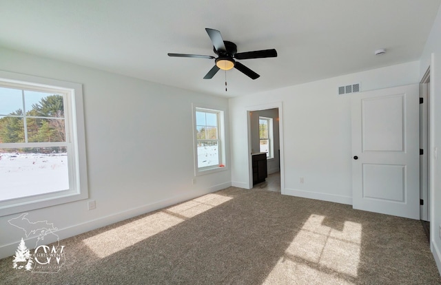 unfurnished bedroom featuring ceiling fan, carpet flooring, and ensuite bath